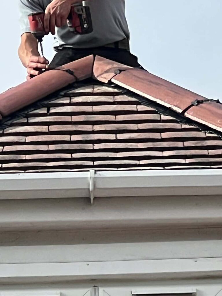 This is a photo of one of the operatives of Cotgrave Roofing Repairs installing new ridge tiles